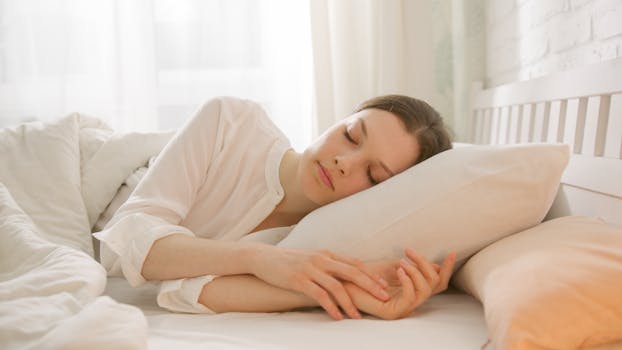 A woman peacefully sleeping in a bright, sunlit bedroom, conveying relaxation and comfort.